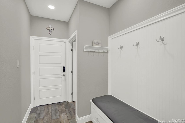 mudroom with dark wood-style floors and baseboards