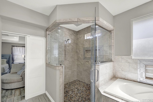 full bath featuring a stall shower, wood finished floors, a bath, and ensuite bathroom