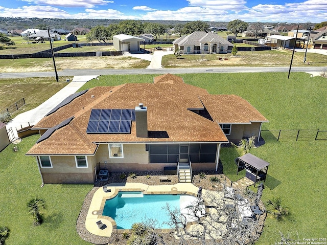 view of pool with fence, a sunroom, a yard, a residential view, and a fenced in pool