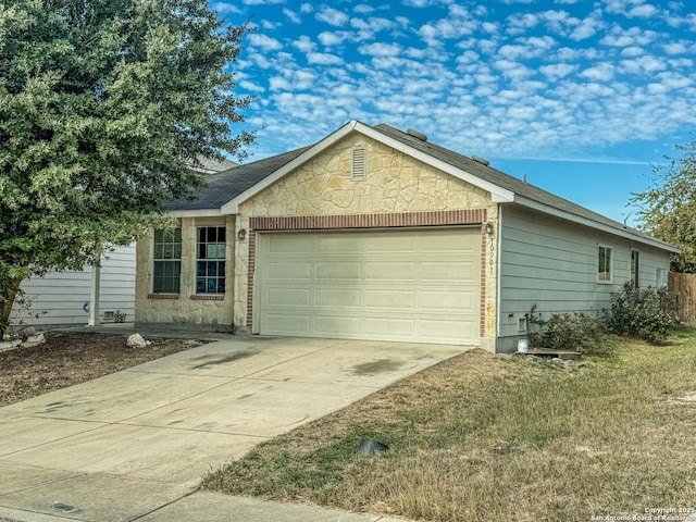 view of front of house featuring an attached garage, stone siding, and concrete driveway