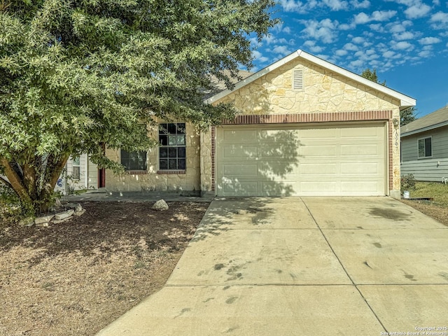 view of front facade featuring stone siding, driveway, and an attached garage