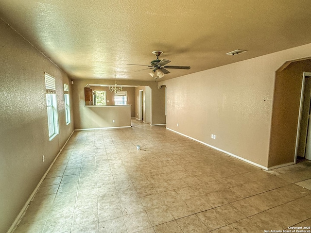 unfurnished room with visible vents, arched walkways, a textured ceiling, and ceiling fan with notable chandelier