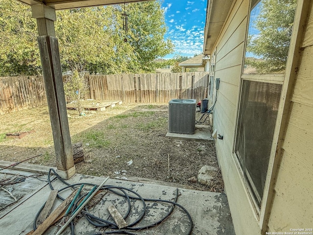 view of yard with a fenced backyard and central AC unit