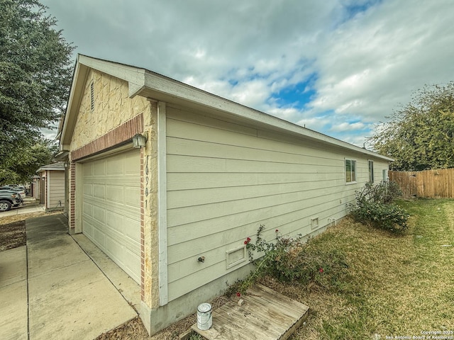 view of side of home featuring a garage and fence