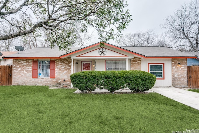 ranch-style house featuring brick siding, fence, and a front lawn