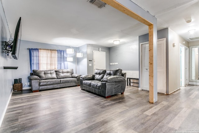 living area featuring visible vents and wood finished floors