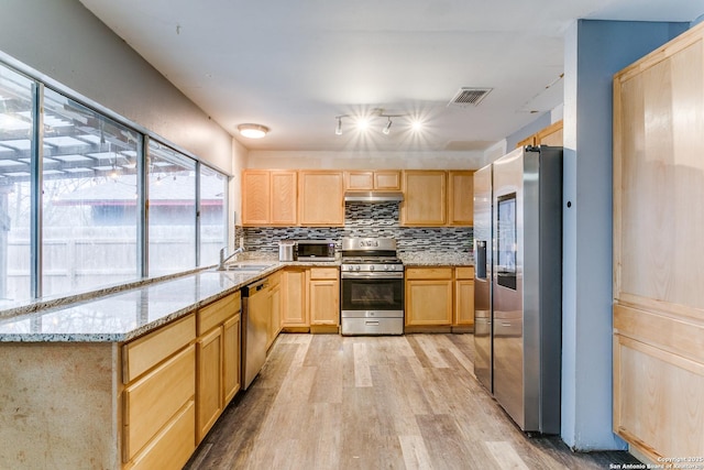 kitchen featuring under cabinet range hood, visible vents, appliances with stainless steel finishes, light brown cabinetry, and light wood finished floors