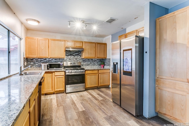 kitchen featuring stainless steel appliances, visible vents, decorative backsplash, light brown cabinets, and a sink