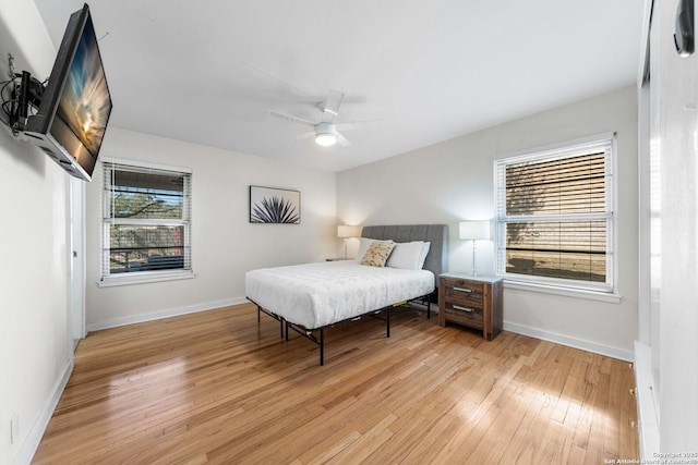 bedroom with light wood-style floors, multiple windows, and baseboards