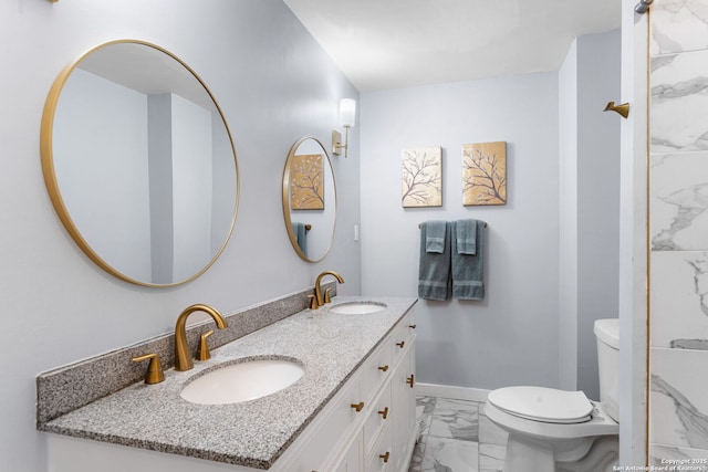 full bath featuring marble finish floor, double vanity, a sink, and toilet