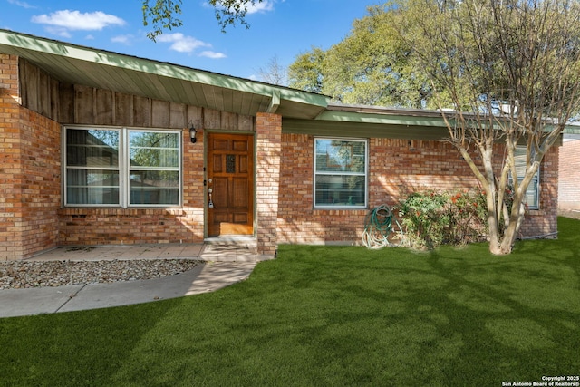 single story home featuring brick siding and a front yard