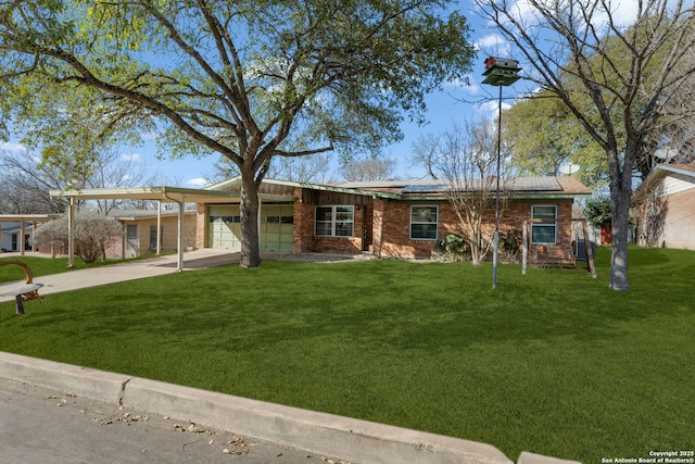 single story home featuring concrete driveway, a front yard, roof mounted solar panels, a garage, and an attached carport