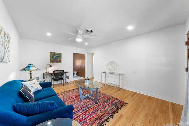 living room with ceiling fan, wood finished floors, visible vents, and baseboards