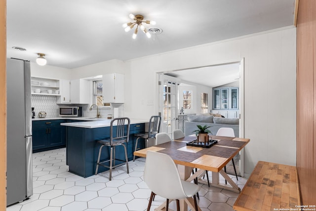 dining room featuring lofted ceiling and visible vents