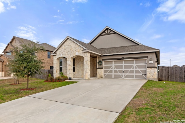 view of front facade with concrete driveway, a front lawn, an attached garage, and fence