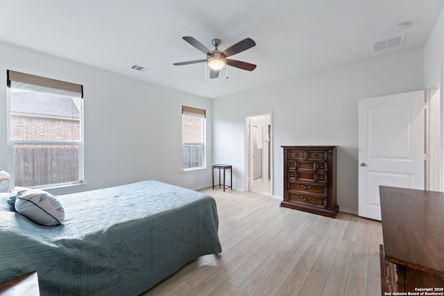 bedroom with visible vents, light wood-style flooring, and baseboards