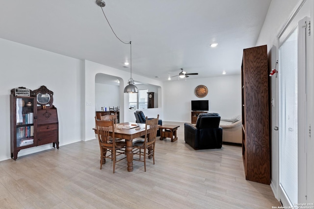 dining area featuring arched walkways, ceiling fan, recessed lighting, baseboards, and light wood-type flooring