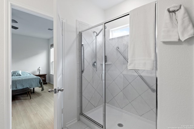 ensuite bathroom with wood finished floors, a shower stall, visible vents, and connected bathroom