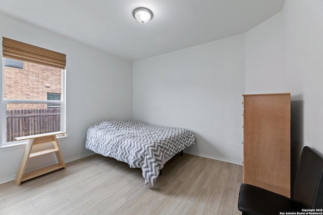 bedroom with light wood-style flooring and baseboards