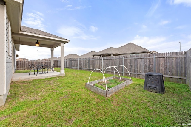 view of yard with ceiling fan, a fenced backyard, a patio area, and a vegetable garden