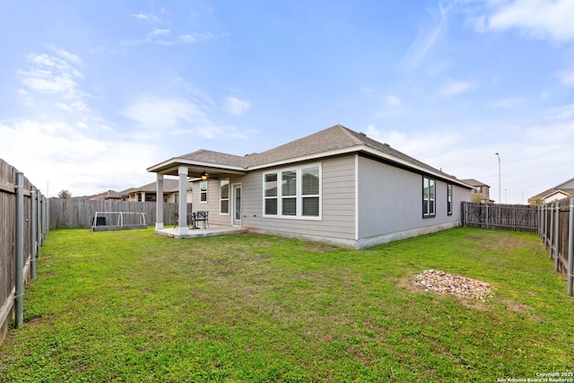 back of house featuring ceiling fan, a lawn, a patio area, and a fenced backyard