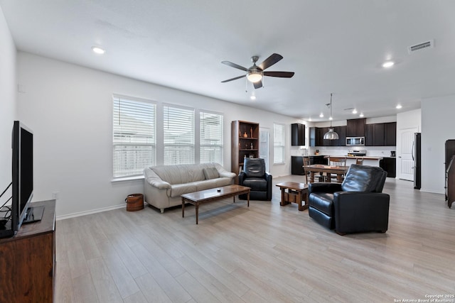 living room with recessed lighting, a ceiling fan, baseboards, visible vents, and light wood-style floors