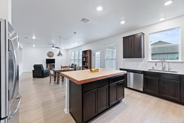 kitchen with visible vents, wood counters, stainless steel appliances, light wood-style floors, and a sink