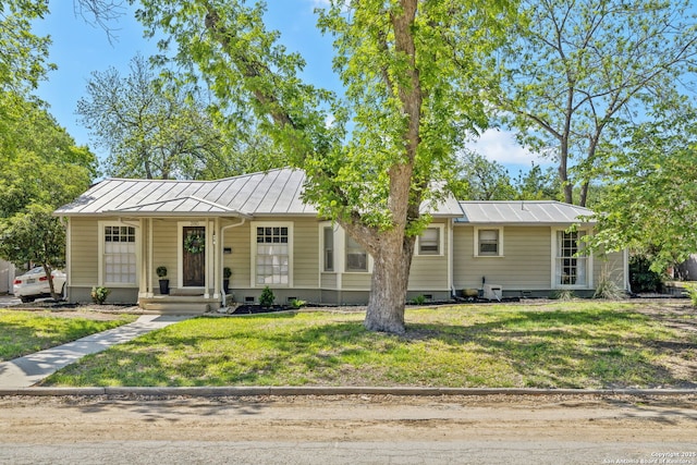 view of front of home featuring a standing seam roof, a front yard, metal roof, and crawl space