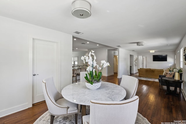 dining space with dark wood-type flooring and baseboards