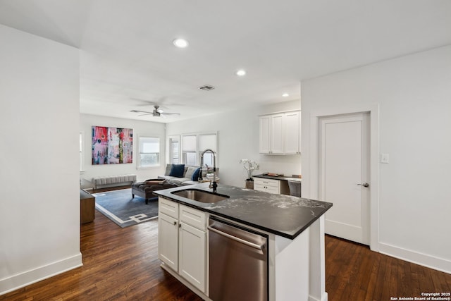 kitchen featuring a ceiling fan, dishwasher, a sink, dark countertops, and open floor plan
