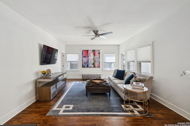 living area featuring dark wood-style flooring, baseboards, radiator, and ceiling fan