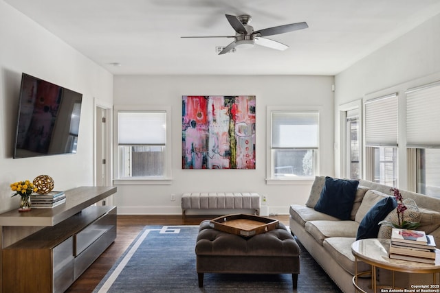 living area with ceiling fan, baseboards, and dark wood finished floors