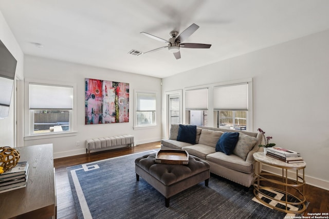 living room with visible vents, ceiling fan, baseboards, and a healthy amount of sunlight