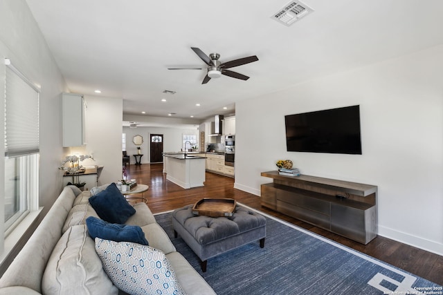living room featuring dark wood-style flooring, baseboards, recessed lighting, visible vents, and ceiling fan