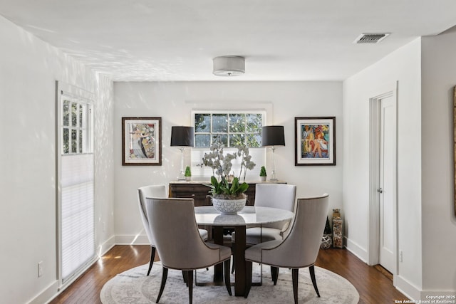 dining room with dark wood-style flooring, baseboards, and visible vents
