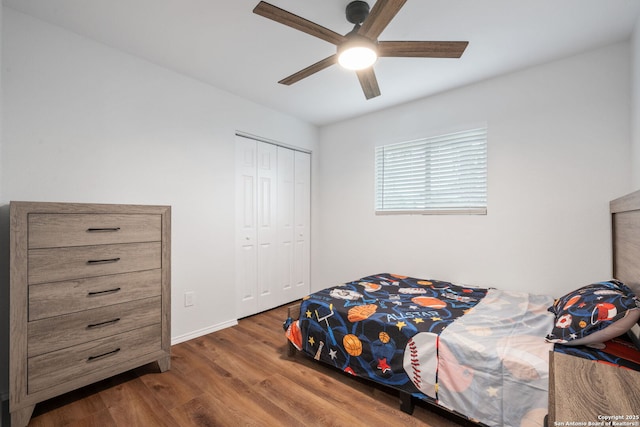 bedroom featuring a ceiling fan, a closet, baseboards, and wood finished floors