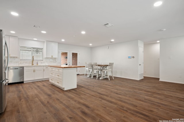 kitchen with appliances with stainless steel finishes, dark wood finished floors, visible vents, and white cabinets