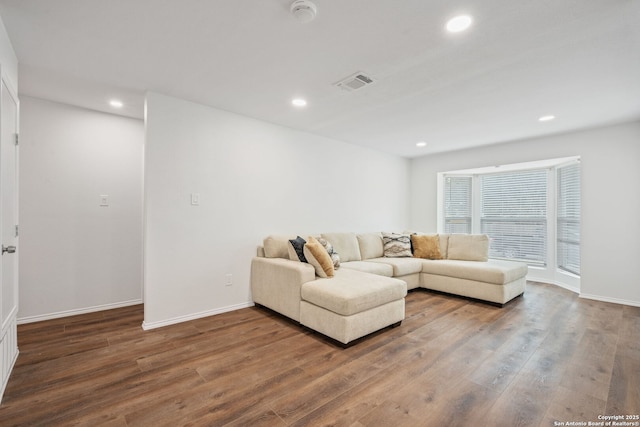 living area with wood-type flooring, visible vents, and recessed lighting