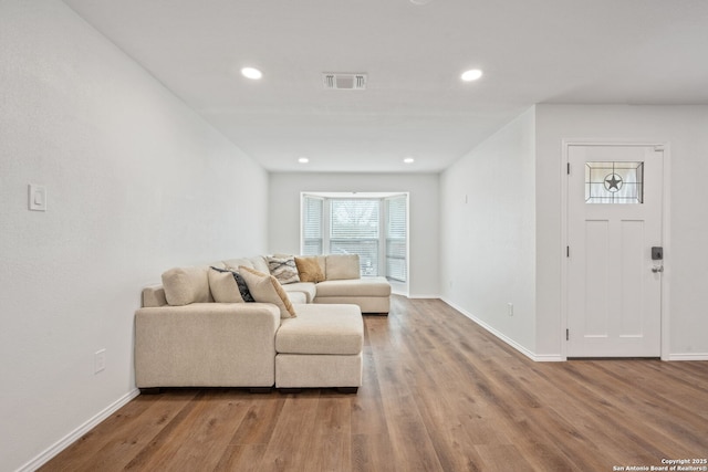 living area featuring recessed lighting, wood finished floors, visible vents, and baseboards