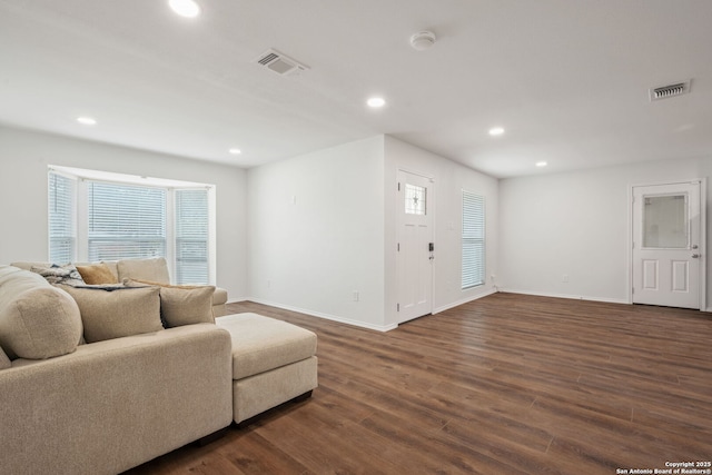 living area featuring recessed lighting, visible vents, baseboards, and wood finished floors