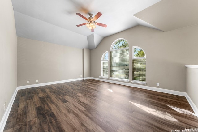 empty room with vaulted ceiling, ceiling fan, wood finished floors, and baseboards