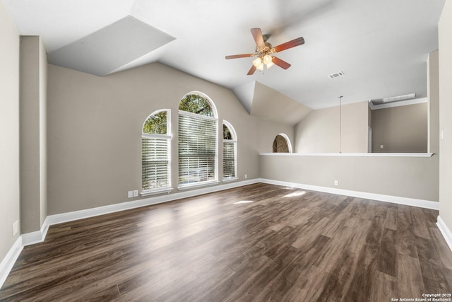 empty room featuring lofted ceiling, a ceiling fan, visible vents, and wood finished floors