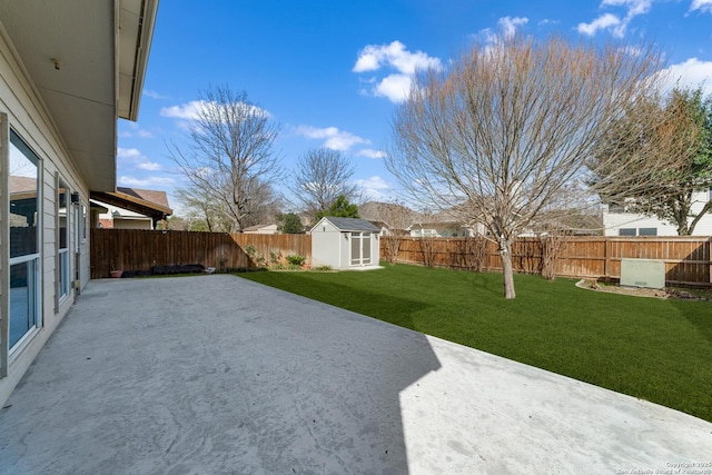 view of yard with an outbuilding, a fenced backyard, a patio, and a shed