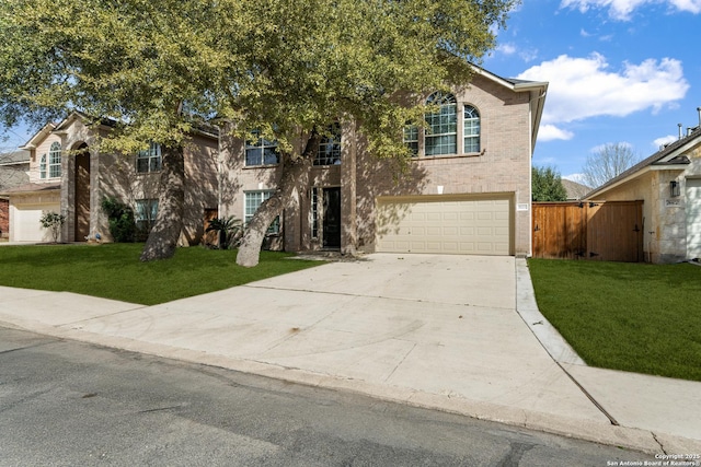 view of front facade featuring a garage, brick siding, fence, driveway, and a front yard