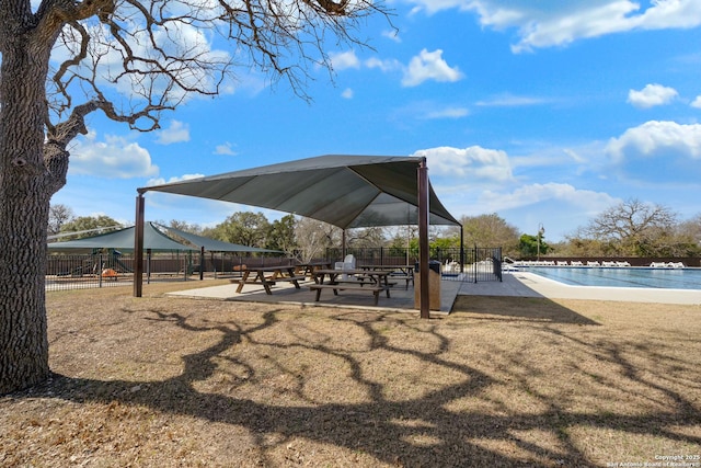 view of community featuring a swimming pool and fence