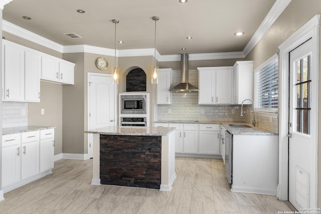 kitchen with stainless steel appliances, a kitchen island, a sink, visible vents, and wall chimney exhaust hood