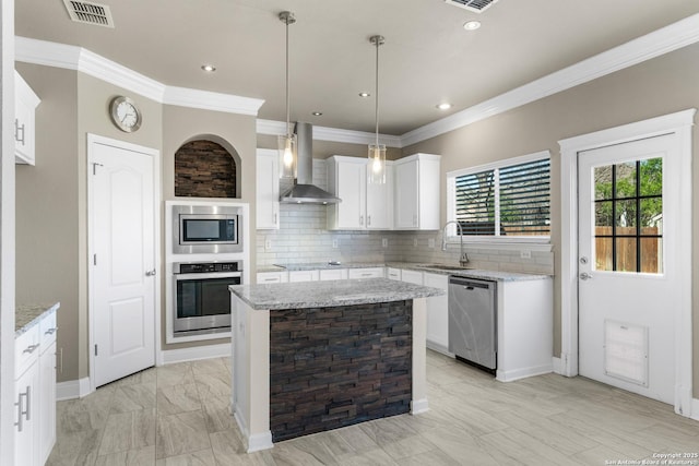 kitchen with wall chimney exhaust hood, appliances with stainless steel finishes, visible vents, and decorative backsplash