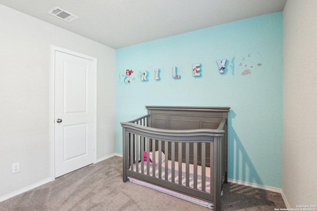 carpeted bedroom with a crib, visible vents, and baseboards