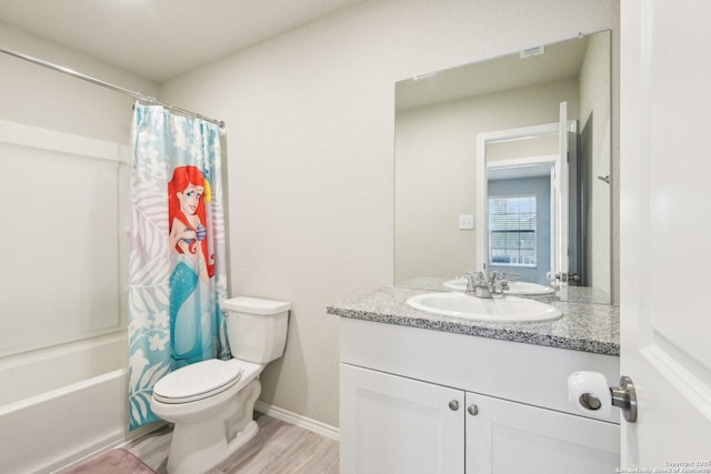 full bath featuring shower / bath combo, baseboards, toilet, wood finished floors, and vanity