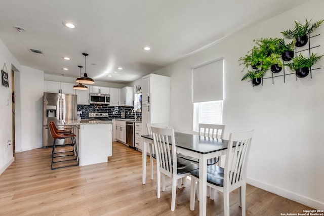 dining room with light wood-type flooring, baseboards, visible vents, and recessed lighting